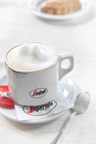 a cup of coffee on a plate with a spoon at Ahotel in Czechowice-Dziedzice