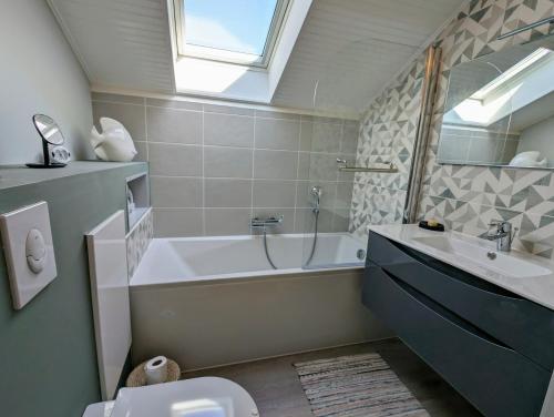 une salle de bain avec une baignoire, un lavabo et des toilettes dans l'établissement Maison spacieuse avec jardin proche plage & centre, à Pornic