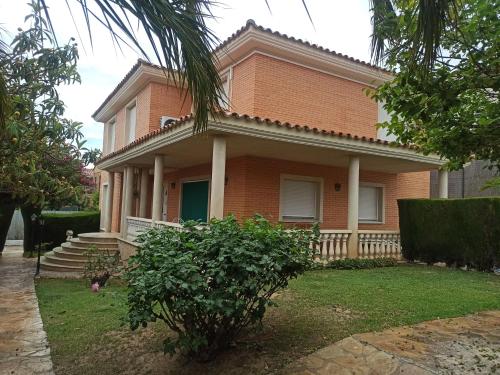 une maison avec un palmier en face dans l'établissement Quevoy, à Alcañiz