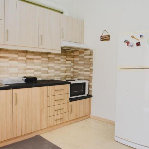 a kitchen with wooden cabinets and a microwave at Relaxation apartment in Messini
