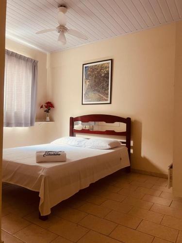 Pousada Castanheira في غواراباري: غرفة نوم بسرير كبير بسقف