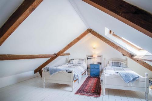 two beds in a attic bedroom with wooden beams at Haggard - 3 Bedroom Cottage - Manorbier in Manorbier