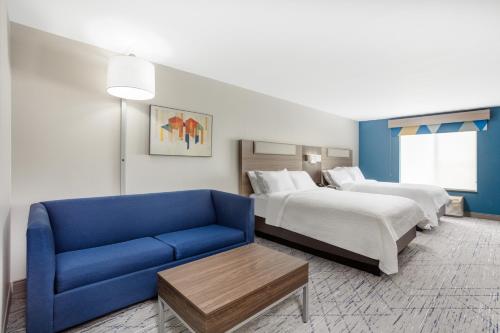 Habitación de hotel con cama y sofá azul en Holiday Inn Express Kearney, an IHG Hotel, en Kearney