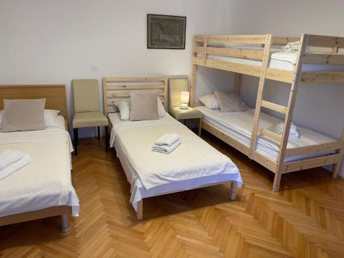 a room with three bunk beds in a room at Apartment House Jerko in Kaštela