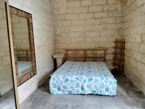1 dormitorio con cama y espejo en Camere Marta, en Minervino di Lecce