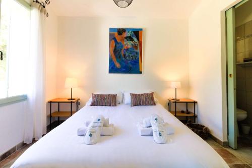 een slaapkamer met een groot wit bed met 2 lampen bij SELECT'SO HOME - Mas au cœur du village de Bormes-les-mimosas - MAS DE LA VERNE in Bormes-les-Mimosas
