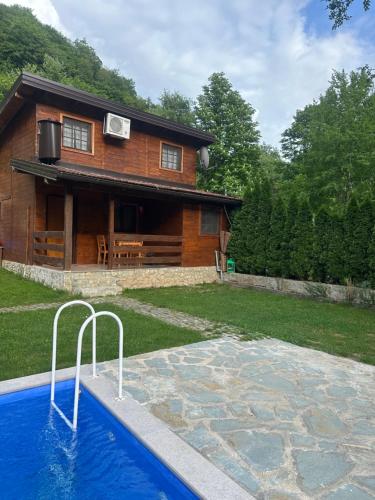 a house with a swimming pool in front of a house at Paradise on the Vrbas River in Jajce