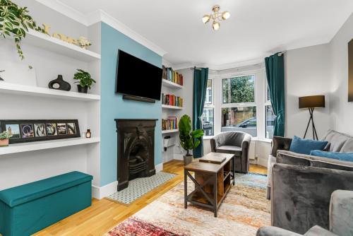 a living room with a fireplace and a tv at Elegant Hither Green Family Home in London