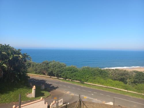an empty road with the ocean in the background at Seaview Unit 1 in Port Shepstone