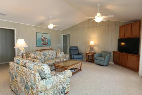 a living room with couches and a flat screen tv at One More Time Again by Pristine Properties Vacation Rentals in Mexico Beach