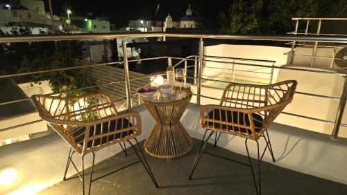 two chairs and a table on a boat at night at Otto house - Luxury cave home in Vóthon