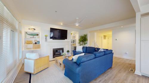 a living room with a blue couch and a fireplace at 7645 Huntington Villa in Hilton Head Island