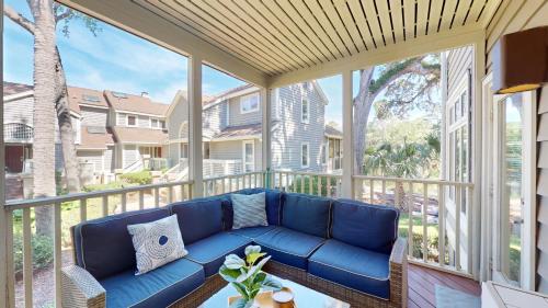 a large screened in porch with a blue couch at 7645 Huntington Villa in Hilton Head Island