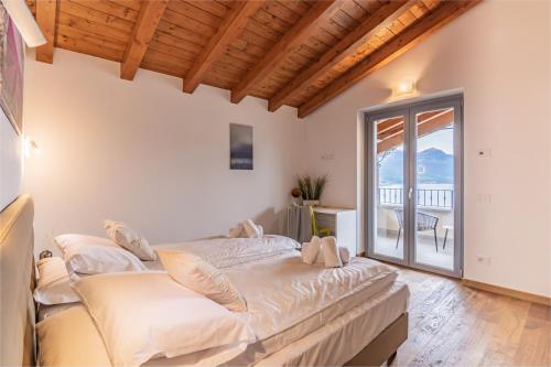 a large bed in a room with a balcony at VILLA SANT'ANNA - ALBA by Curtiaffitti in Pianello Del Lario
