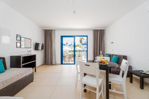 a living room with a table and a dining room at Kritamo Beach Hotel Apartments in Ayia Napa