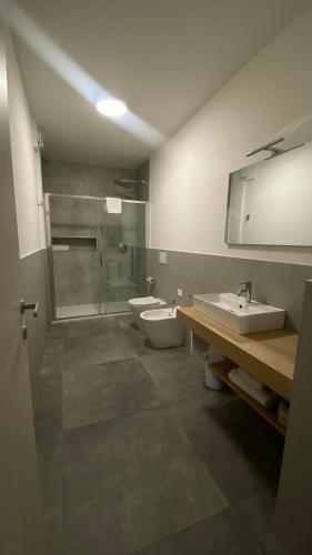 a bathroom with two sinks and a shower and two toilets at Dormi-RE Affittacamere in Reggio Emilia