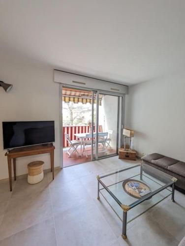 un salon avec un canapé et une table en verre dans l'établissement 2 pièces lumineux à Cagnes sur mer, à Cagnes-sur-Mer