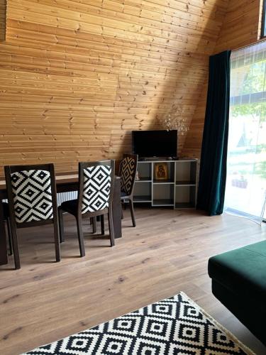 a living room with a dining room table and chairs at The Frog Glamping in Horezu
