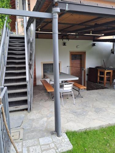a patio with a table and chairs and stairs at CASA GIo in Aosta
