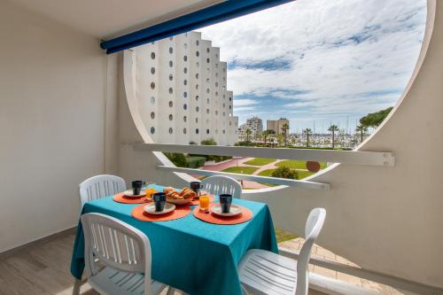 une pièce avec une table et des chaises et une grande fenêtre dans l'établissement Spacieux studio cabine-Parking gratuit-Clim-Proche centre & Mer-Vue Port LGM, à La Grande Motte