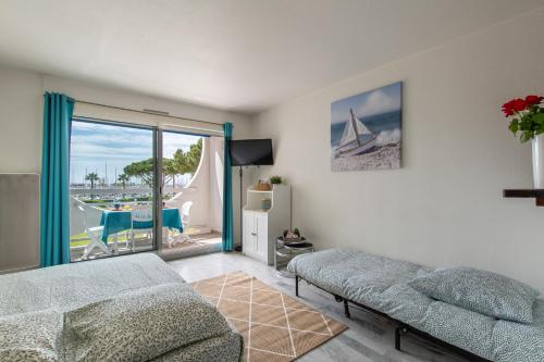 un salon avec un canapé et une vue sur l'océan dans l'établissement Spacieux studio cabine-Parking gratuit-Clim-Proche centre & Mer-Vue Port LGM, à La Grande Motte