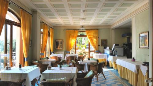 uma sala de jantar com mesas e cadeiras brancas em Hotel Locanda Ruscello Garnì em Limone sul Garda
