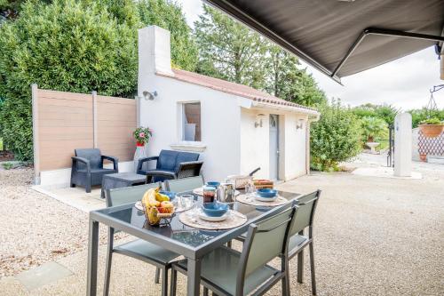une table et des chaises dans une arrière-cour avec une maison dans l'établissement Four You, à Lairoux