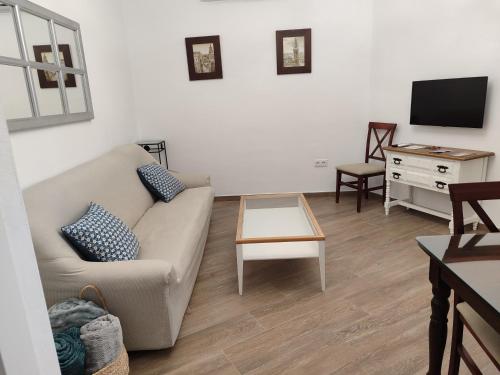 Casa dúplex en el centro في كارمونا: غرفة معيشة مع أريكة وطاولة