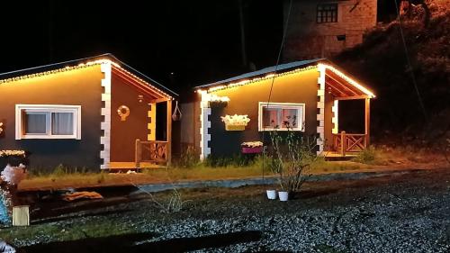 uma pequena casa com luzes à noite em DEĞİRMEN KÖY EVLERİ em Çamlıhemşin