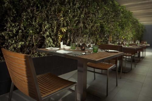 a table with chairs and wine glasses in a restaurant at Liberty Central Saigon Citypoint in Ho Chi Minh City