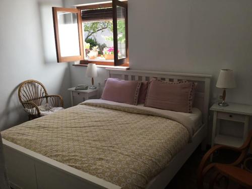 een slaapkamer met een bed met twee kussens en een raam bij Casa Las Almenillas in Antequera