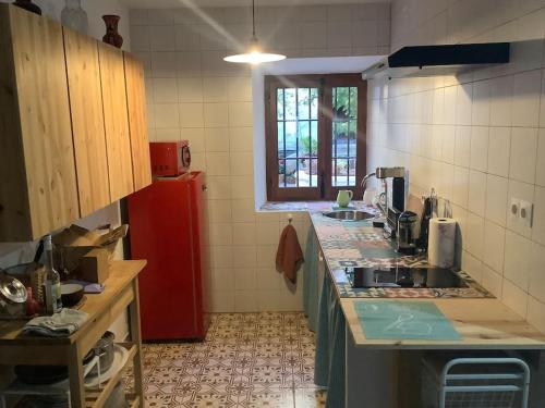 een keuken met een wastafel en een rode koelkast bij Casa Las Almenillas in Antequera