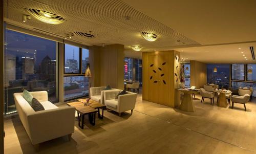 a hotel lobby with chairs and tables and windows at Liberty Central Saigon Citypoint in Ho Chi Minh City