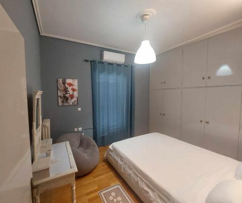 a small bedroom with a bed and a chair at Downtown Apartment Karystos in Karistos