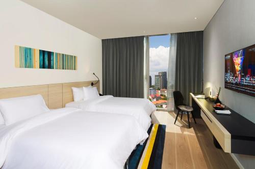 a hotel room with two beds and a television at Liberty Central Saigon Citypoint in Ho Chi Minh City