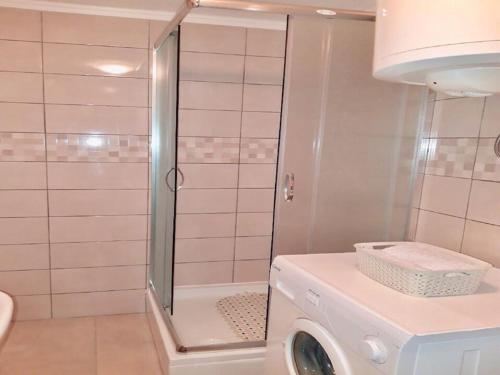 een badkamer met een douche en een wasmachine bij Apartment Ines in Dubrovnik
