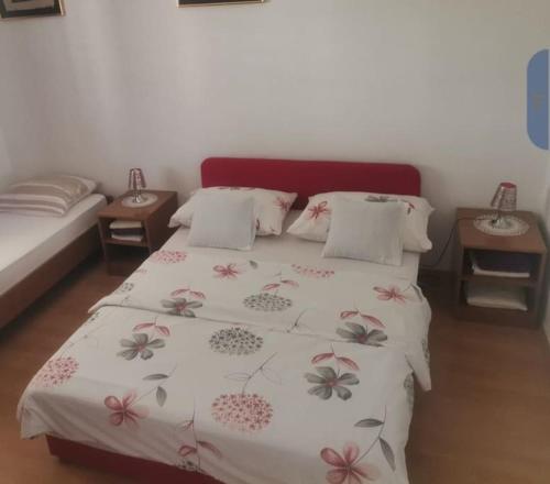 1 dormitorio con 1 cama con edredón blanco con flores en Apartment Ines, en Dubrovnik
