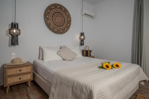 Un dormitorio blanco con una cama con girasoles. en Tropical Studios, en Laganas