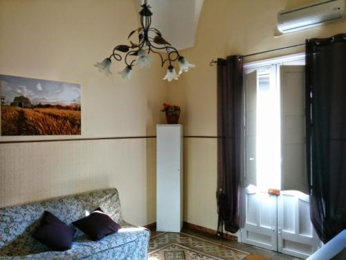 ein Wohnzimmer mit einer Couch und einem Fenster in der Unterkunft Casa Vacanze Nonna Vincenza in Neviano