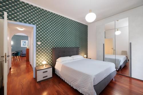 a bedroom with a white bed and a green wall at C 'est la Vie in Lido di Ostia