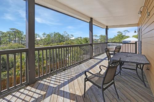 a patio with a table and chairs on a deck at Big Chill by Pristine Property Vacation Rentals in Cape San Blas