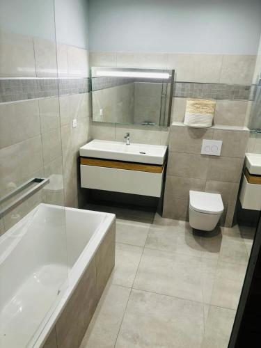 une salle de bain avec une baignoire, un lavabo et des toilettes dans l'établissement Appartement moderne à Ajaccio de 45 m² avec terrasse vue mer, à Ajaccio