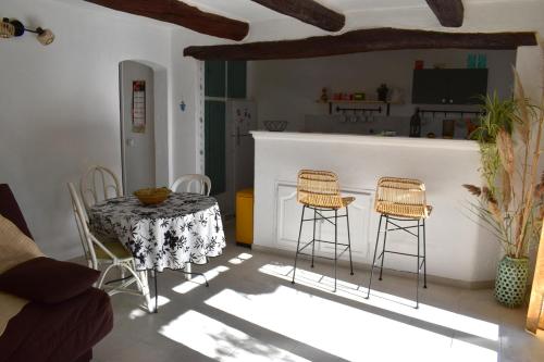 eine Küche mit Tisch und Hockern in einem Zimmer in der Unterkunft Grand studio avec jardin à Saint-Aygulf in Fréjus