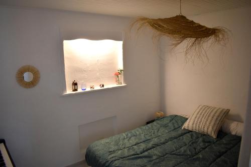 une chambre avec un lit vert et une fenêtre dans l'établissement Grand studio avec jardin à Saint-Aygulf, à Fréjus