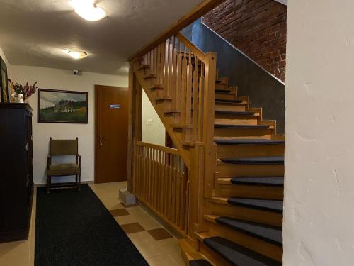 a wooden staircase in a room with a brick wall at Pod Orlicą in Duszniki Zdrój