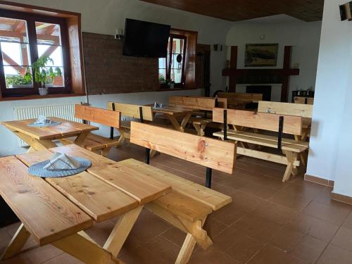 a restaurant with wooden tables and benches in a room at Pod Orlicą in Duszniki Zdrój