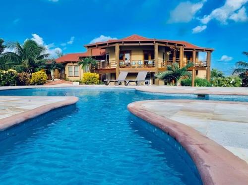 une maison avec une piscine en face d'une maison dans l'établissement Villa Serenity, à San Pedro