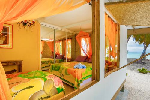 a bedroom with two beds and a view of the ocean at Fafarua Private Island in Tikehau