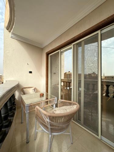 um quarto com uma mesa e cadeiras e uma grande janela em Crowne Pyramids view inn no Cairo
