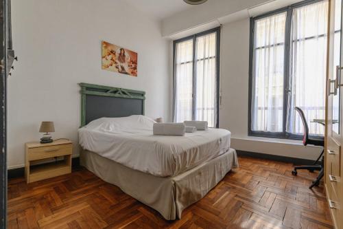 une chambre avec un lit dans une pièce avec des fenêtres dans l'établissement Charmant appt 3 chambes au coeur de Nice-5 mns plages, à Nice